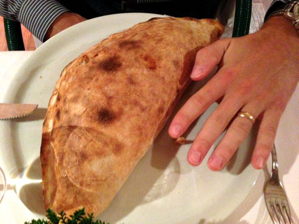 Adam's hand compared to a calzone he had in Austria