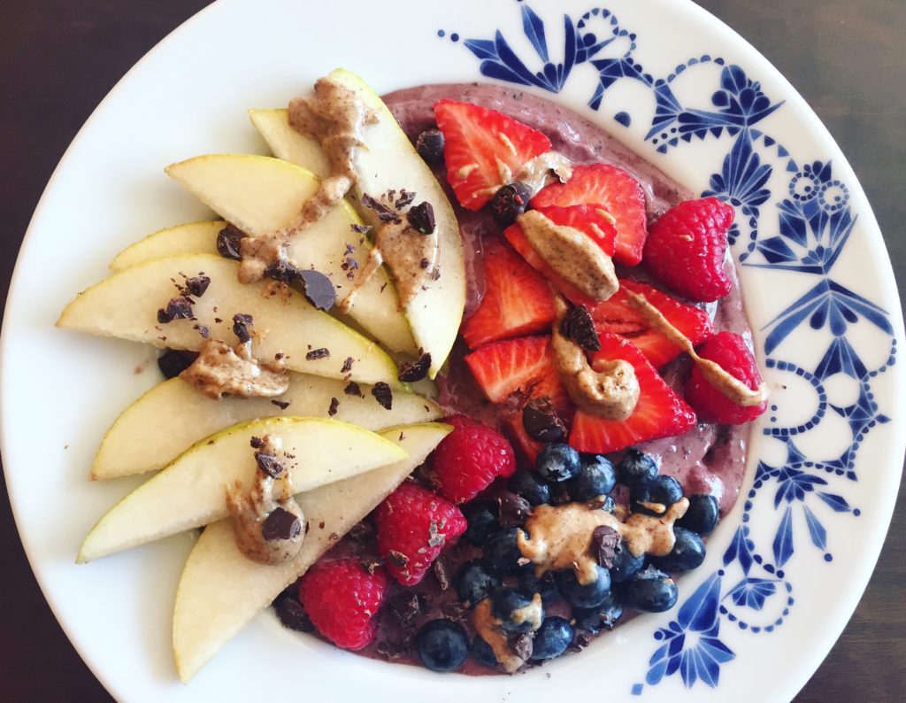 A berry protein smoothie bowl with lots of yummy toppings